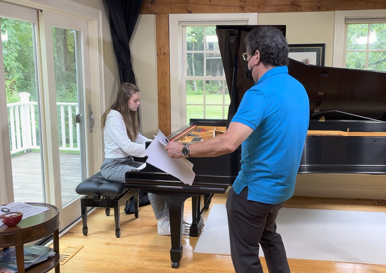 Lauren teaching a young piano student at the keyboard